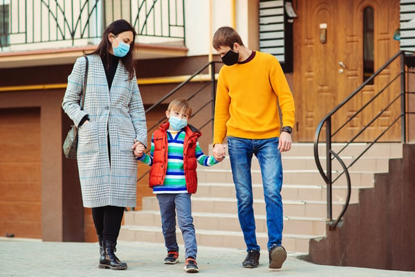 Family goes for a walk while wearing masks